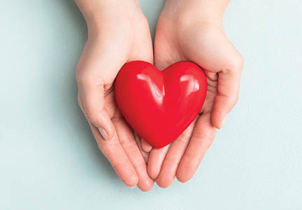 The woman is holding a red heart. Concept for charity, health insurance, love, international cardiology day.