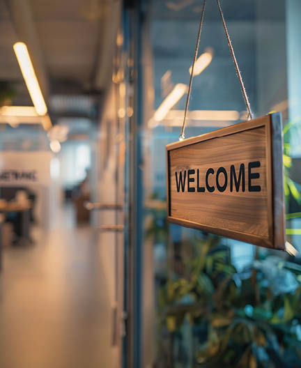 A 'Welcome' sign hanging on an office door, greeting a new employee on their first day, symbolizing a fresh start and new job opportunities