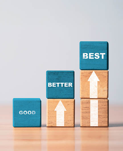 Good better and best wording on blue wooden cube block with white up arrow for product and service quality continuous improvement or Kaizen concept.