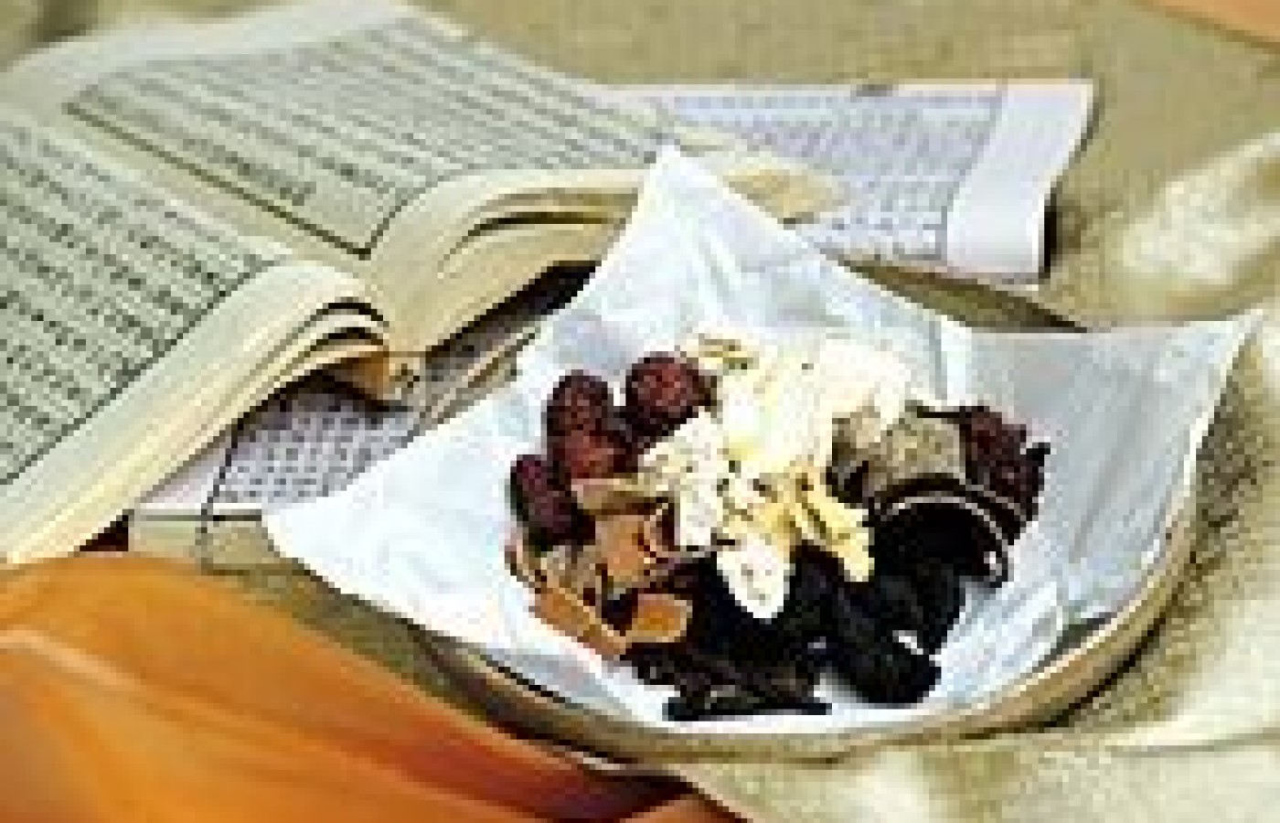 A bowl of herbs on top of Oriental Medicine textbooks.